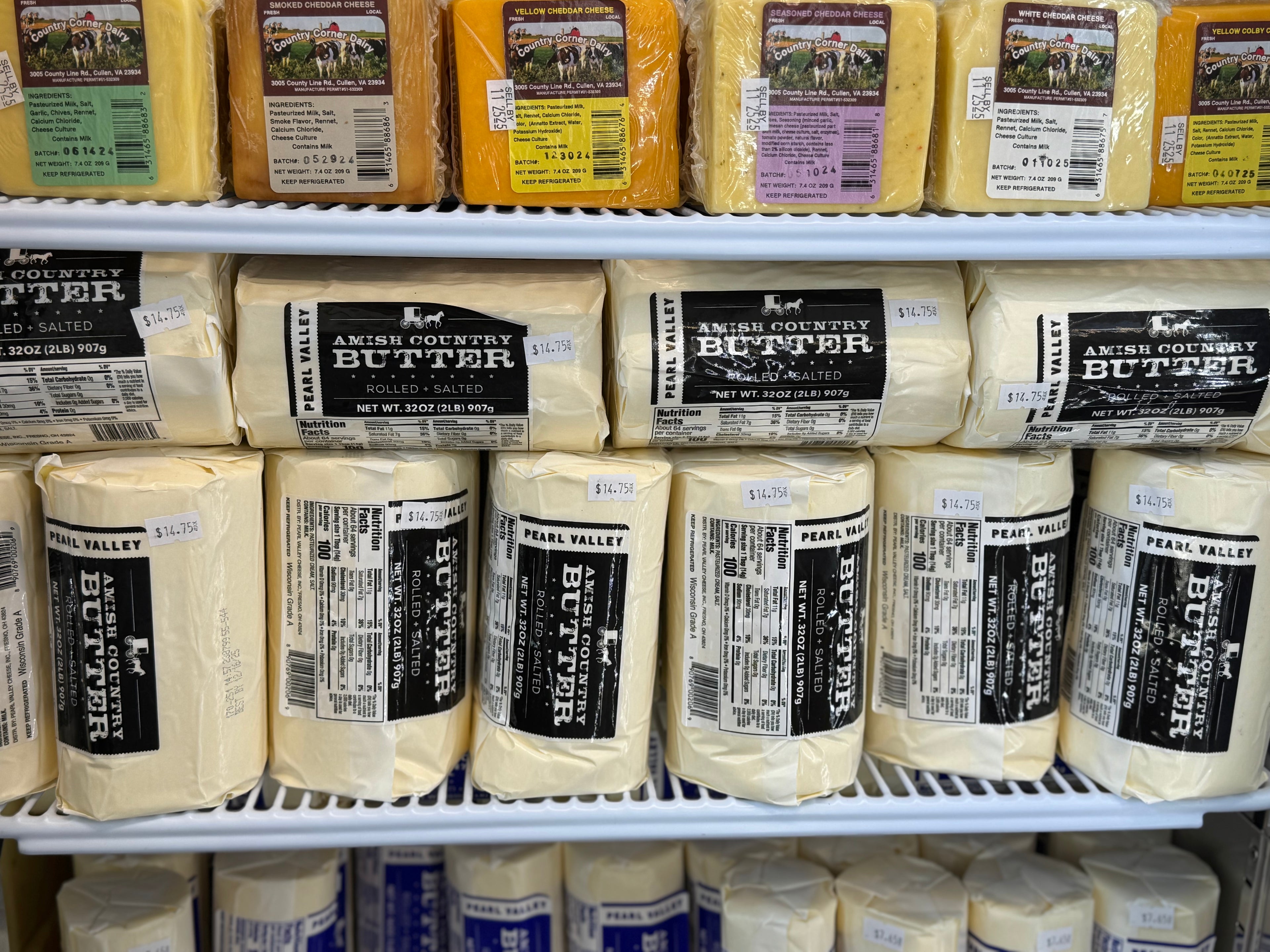 Display of Pearl Valley butter blocks with labels on a shelf.