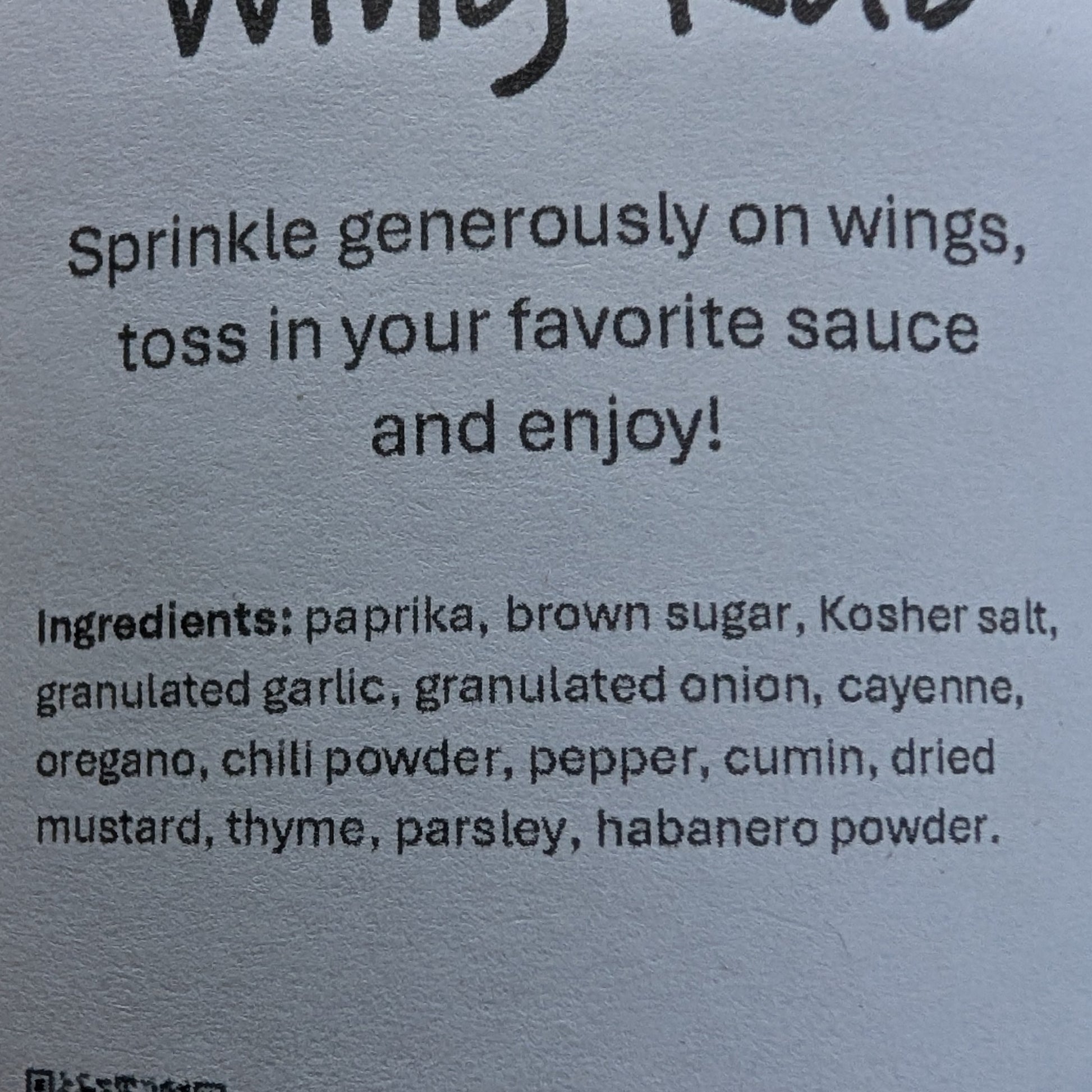 Label for 'Born' Wing Rub on a brown background